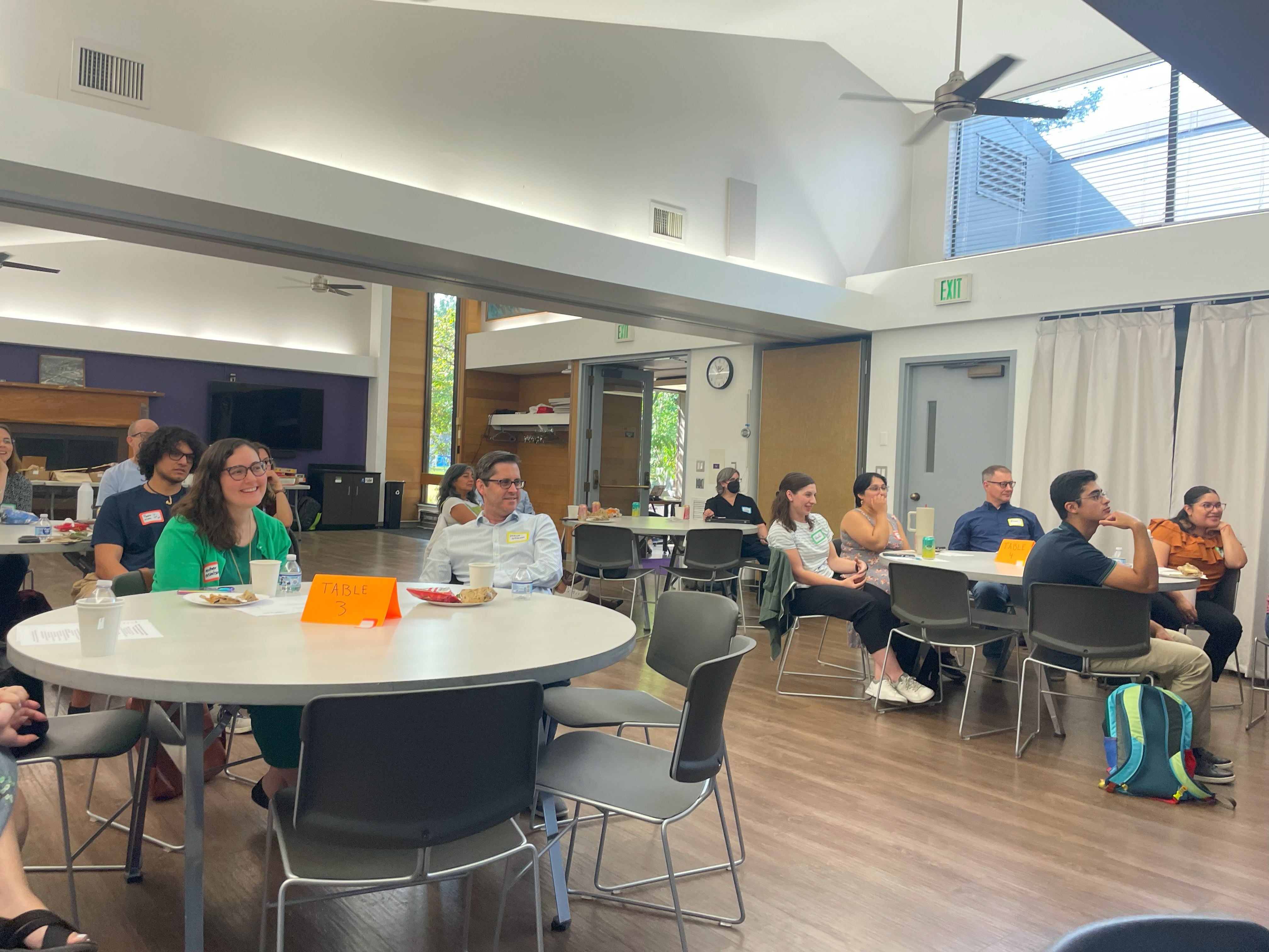 people sitting at tables watching presenter at program retreat